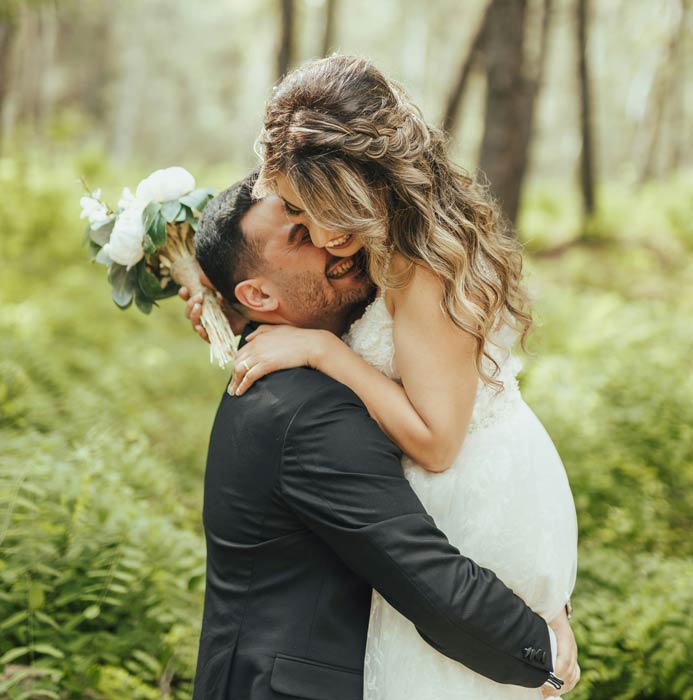 Wedding couple standing in a field of wildflowers with mountains